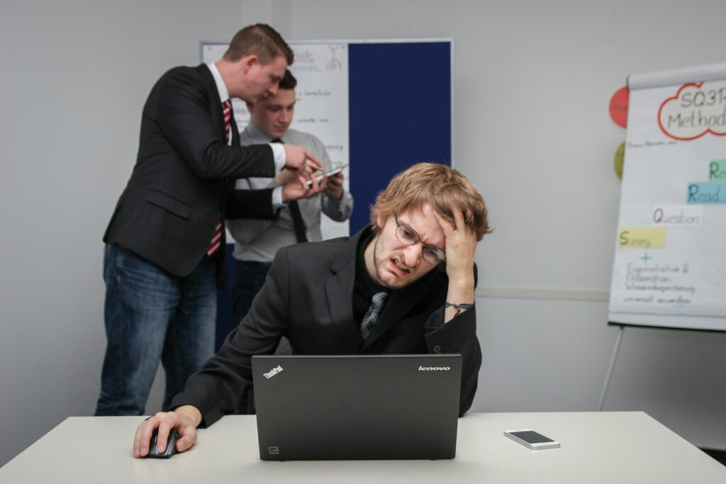 man sitting on chair using gray Toshiba ThinkPad